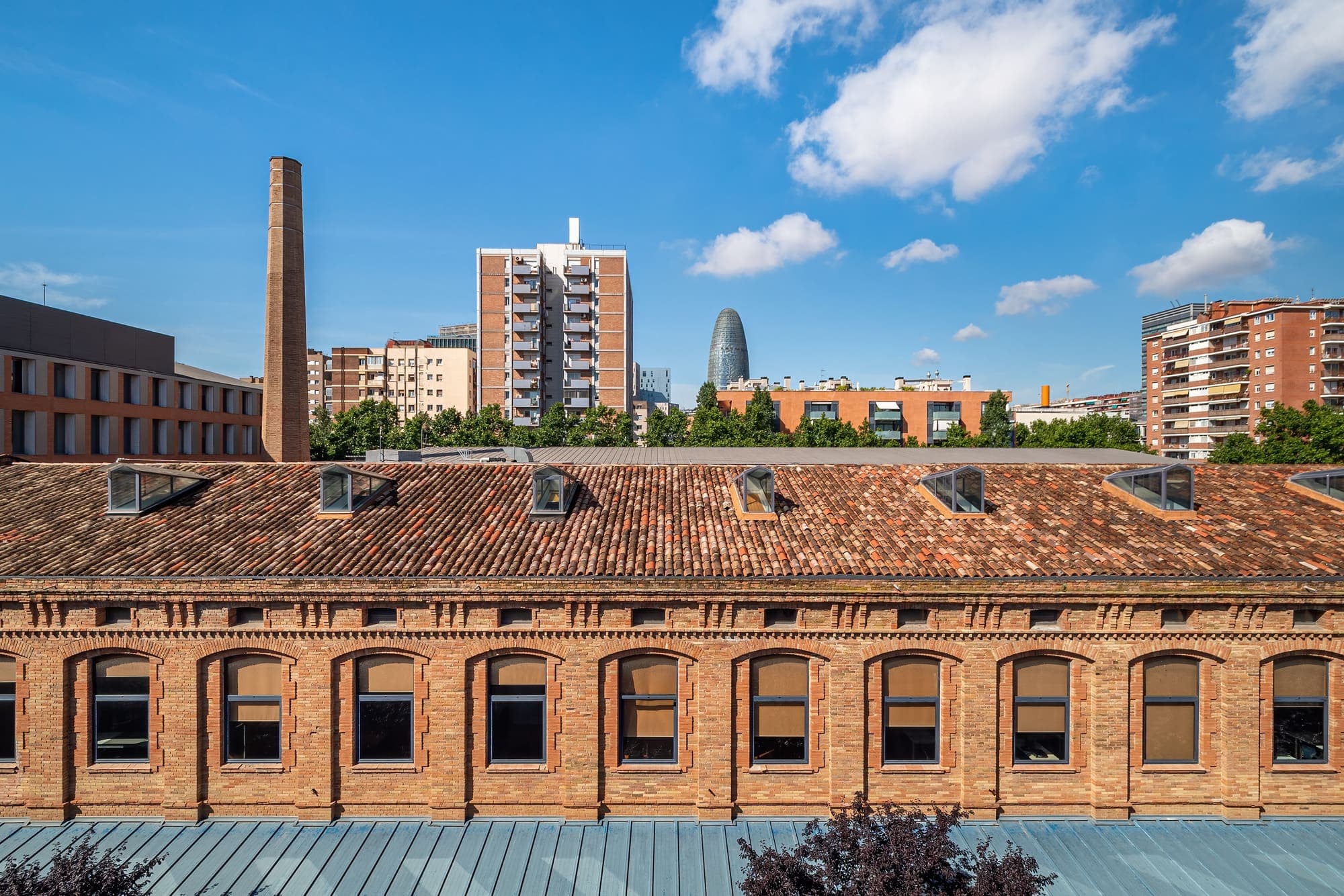 Antiguas naves industriales del Poblenou con la Torre Glòries al fondo, en Sant Martí